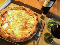 a pizza with a big edge of cheese just in its wrapping, to that a salad and chianti