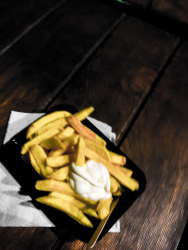 a portion french fries with mayonnaise in the middle of the night