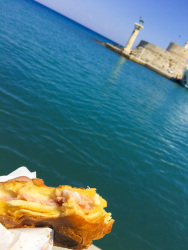 a greek ham and cheese pie is just being eaten at the sea