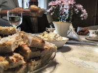 a coffeetable with butter cake, cream and a bunch of pink flowers