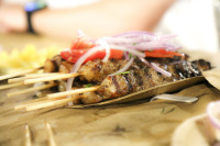 some suflaki skewers with onions and tomatoes on the top