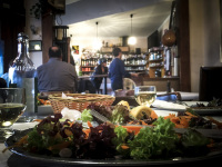 a greek meal with a lot of green salad in a greek tavern