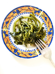 delicious greek chorta on a plate with a fork ready to eat it