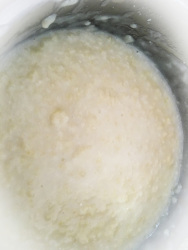 greek trachana cooks with water and butter in a cooking pot