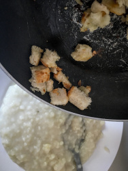 peaces of white bread are fried with oil in a pan to top the greek trachana