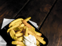 a portion french fries with mayonnaise in the middle of the night