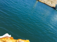a greek ham and cheese pie is just being eaten at the sea