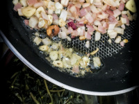to sear the cutted garlic and onions in butter for preparing greek chorta