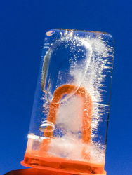 an orange ice mold with water ice in front of a blue sky
