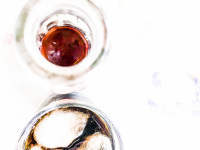 coca cola in a glassbottle and with ice cubes in a drinkglass