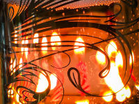 a glass filled with champagne with candles in the background