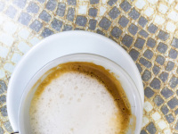 on an artful stony mosaik is standing a cup with yummi cappuccino