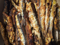 light brown crispy fried anchovies with juice of lemon