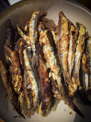 light brown crispy fried anchovies with juice of lemon