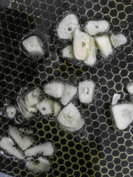 to sear garlic in butter in a pan for prepairing garlic potatoes
