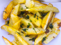 crusty fried garlic potatoes with parsley ready to eat