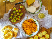 a tv-picknick with treats like strawberries, grapes, apricots, potatoe chips, cheese and grape skewers, little pizza, pie and various cheese