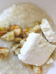 the last top for the greek trachana with peaces of white bread is fresh feta on the top