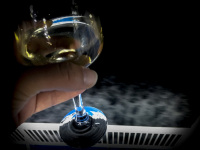 someone is holding by night a glass of white wine on the railing of a ship