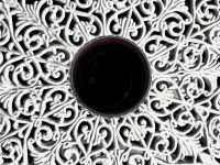 a glass of red wine in the middle of a white tabel of cast iron
