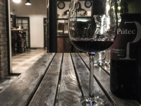 a glass and a bottle of slovak red wine on a wooden table in a restaurant