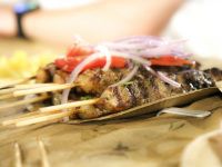 some suflaki skewers with onions and tomatoes on the top