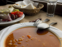 a plate of bean soup in front of a window in a mountain landscape
