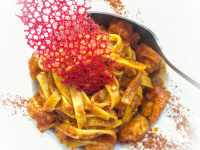 a portion tagliatelle with a red filigree decoration on it