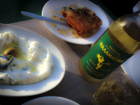 malamatina retsina in a glass and in a bottle to that a plate of tzatziki and a plate of feta with honey