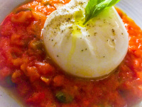 on top of a red tomatoe sauce is laying a buffallo mozarella with some basil