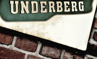 an old advertising sign of the herbal liqueur underberg at a wall of red bricks