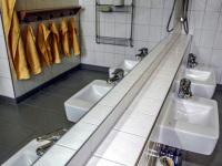 small washbasins and orange towels in a bathroom in a kindergarden