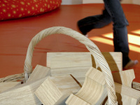 big wooden building blocks are laying in a basket in a kindergarden