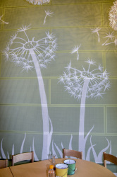 on a light green wall painted dandelions in a kindergarden wich named dandelions