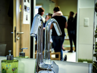 the water tap of a washroom in a kindergarden in front of a mirror