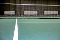 a tennis court with three white heater in the background