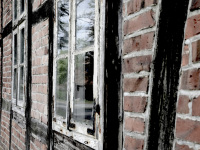 the facade of an old half-timbered with old windows and red briks near bergen in lower saxony