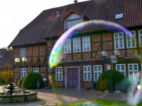 a big soap bubble in front of the facade of the event building of the city bergen in lower saxony