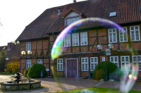 a big soap bubble in front of the facade of the event building of the city bergen in lower saxony