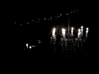 a chandelier, candles and fairy lights in a nightly garden, black-and-white