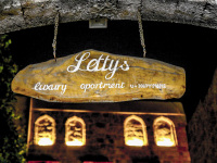 a wooden sign in the old town of rhodes points out of letty\'s luxury apartment