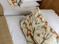 a double bed at a wooden wall with white and colored pillows in the philippos hotel in athens