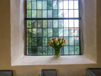 a bouquet of tulips in front a glass mosaic window in the church St. petri in großburgwedel in lower saxony