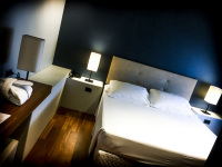 the white bed in front of a blue wall in the regent boutique hotel & spa in san marino