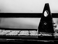 an old metronome and a lace blanket on a piano in the lounge of the elafos hotel on rhodes, black-and-white