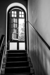 stairs are leading to a door arch and some windows in the hotel elafos on rhodes, black-and-white
