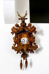 a light brown wooden cuckoo clock with the head of a deer in the elafos hotel on rhodes