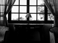 armchairs, curtains, a lamp and a table in front of a window in the lounge of the elafos hotel on rhodes