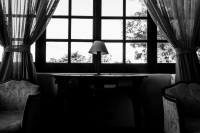 armchairs, curtains, a lamp and a table in front of a window in the lounge of the elafos hotel on rhodes