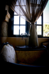 a stylish sitting area with armchairs in front of a window in the elafos hotel on rhodes